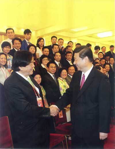 图为习近平(右)与中国侨商投资企业协会常务副会长、马来西亚常青集团董事局主席张晓卿(左)握手。中新社发 盛佳鹏 摄